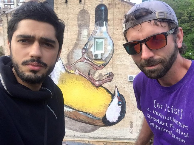 Активист Гео Лерос и художник Alex Maksiov на фоне мурала Синица