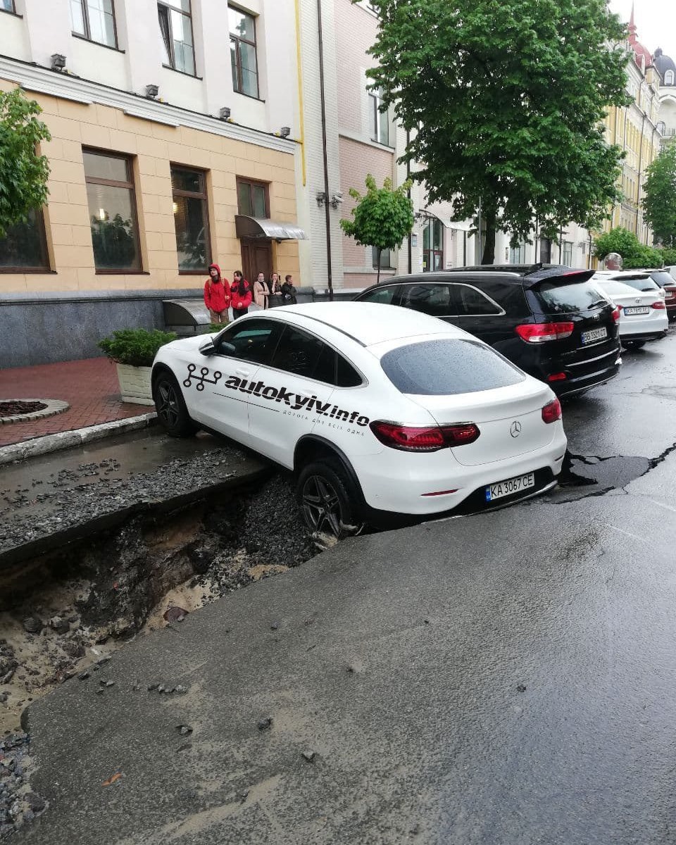 У центрі Києві після сильного дощу розмило дорогу: Мерседес провалився під асфальт