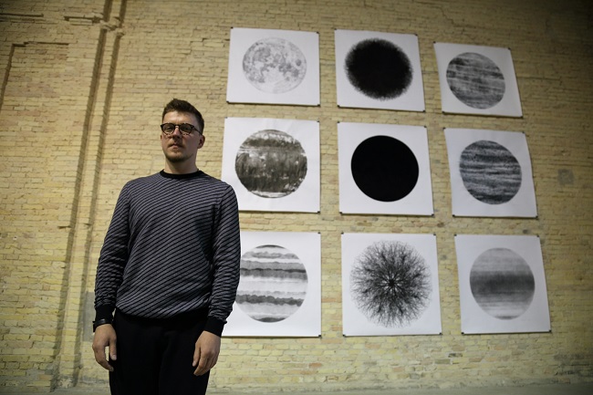 Художник Сергей Погребинский на фоне своих работ 