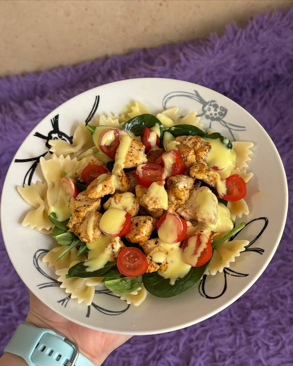 Паста-салат із куркою та шпинатом на тарілці
