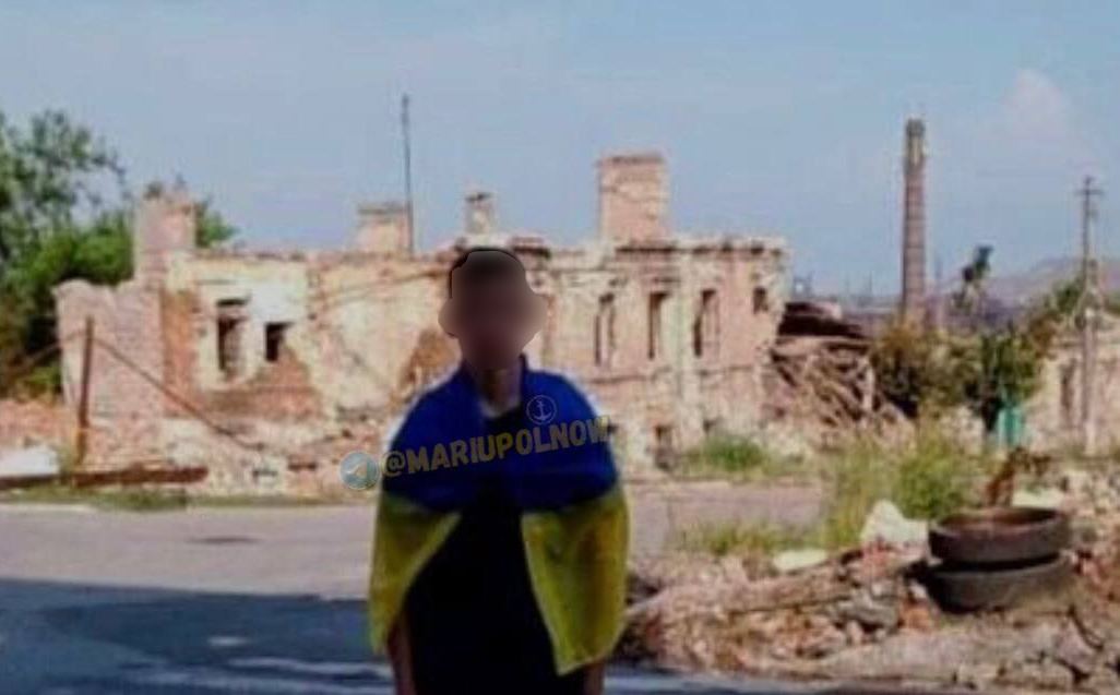 В Мариуполе парень сфотографировался возле разбомбленного дома с флагом Украины
