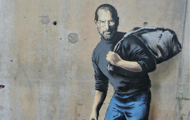 Бэнкси нарисовал Стива Джобса в образе мигранта на стене лагеря для беженцев в Кале
